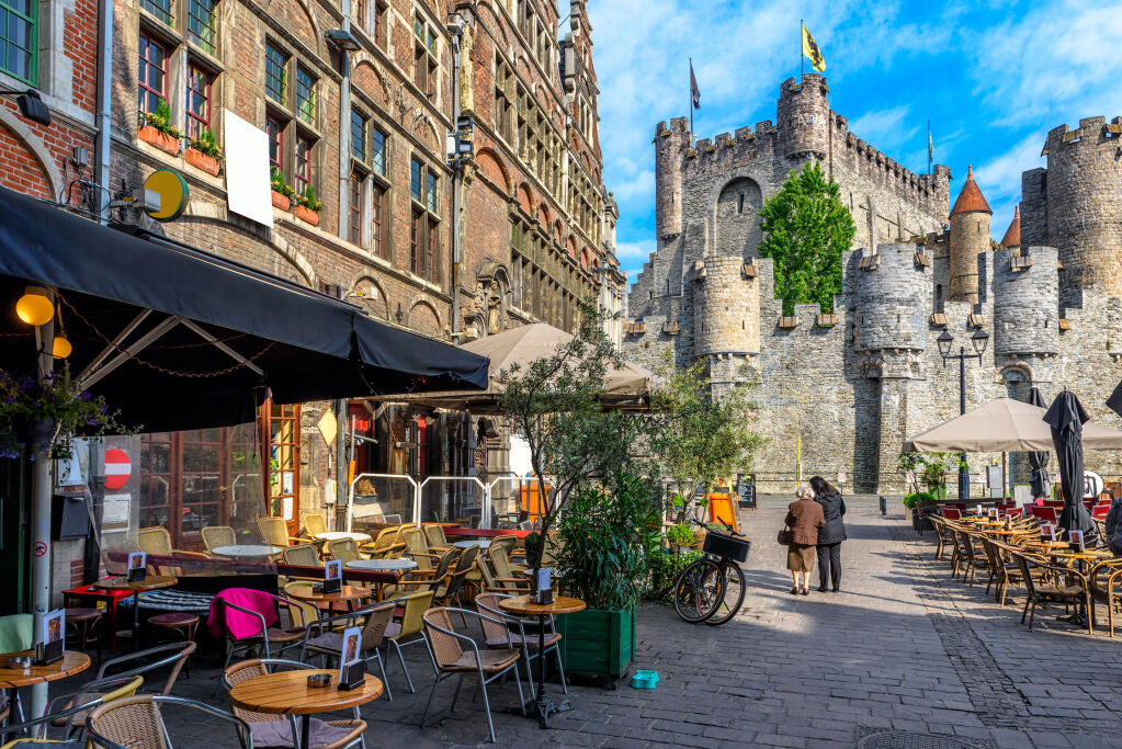 Stara ulica ze stołami kawiarni w Gandawie (Gent), Belgia. Architektura i punkt zwrotny w Gandawie. Przytulny pejzaż Gandawy.