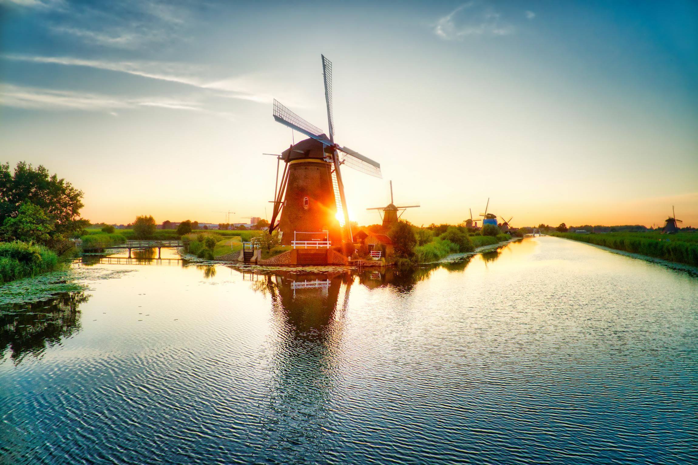 Widok z lotu ptaka na tradycyjne wiatraki o zachodzie słońca w Kinderdijk w Holandii. Ten system 19 wiatraków został zbudowany około 1740 roku i znajduje się na liście dziedzictwa UNESCO.