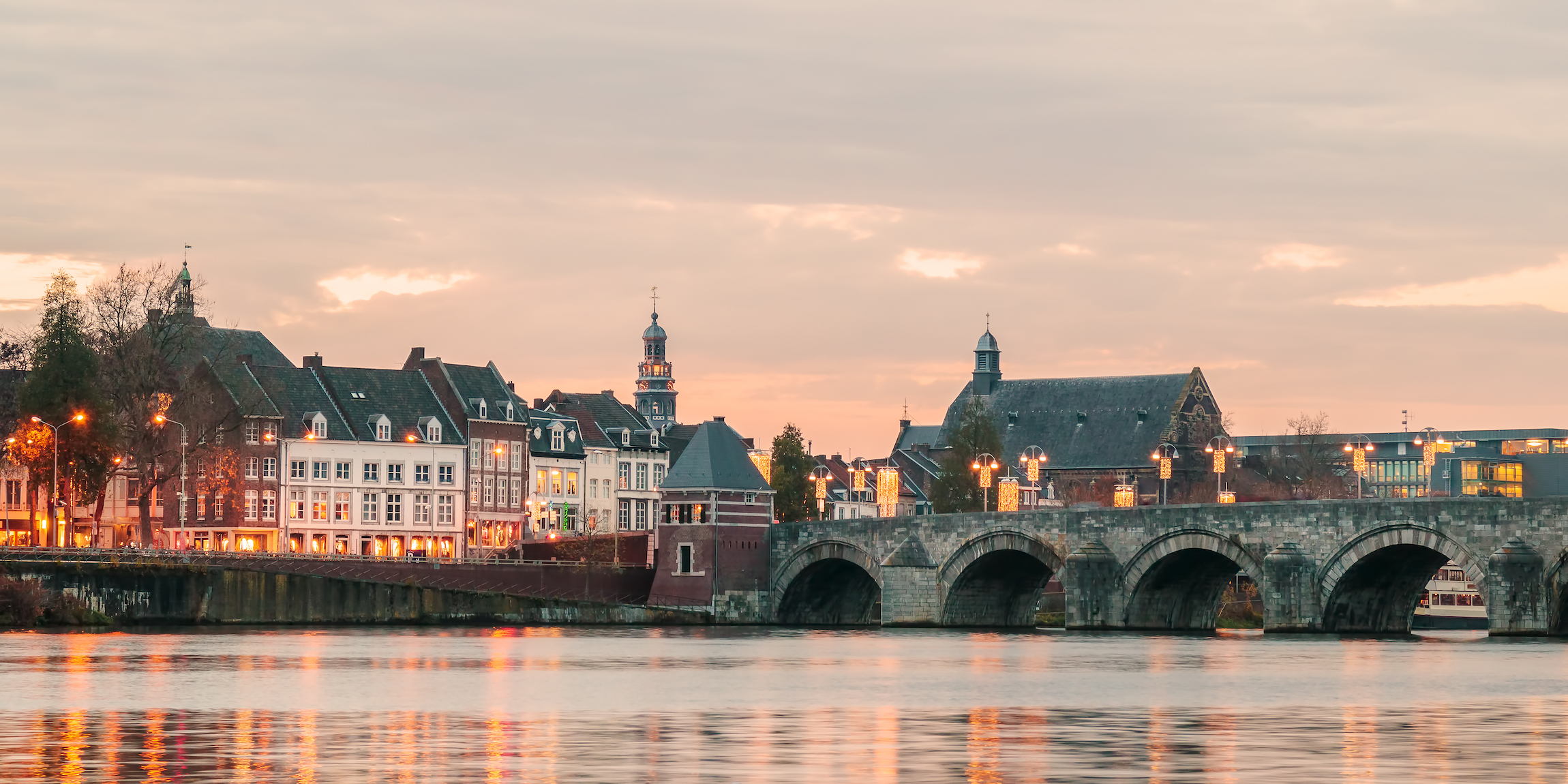 Panoramiczny widok na słynny holenderski Sint Servaas mostu ze światłami w centrum miasta Maastricht