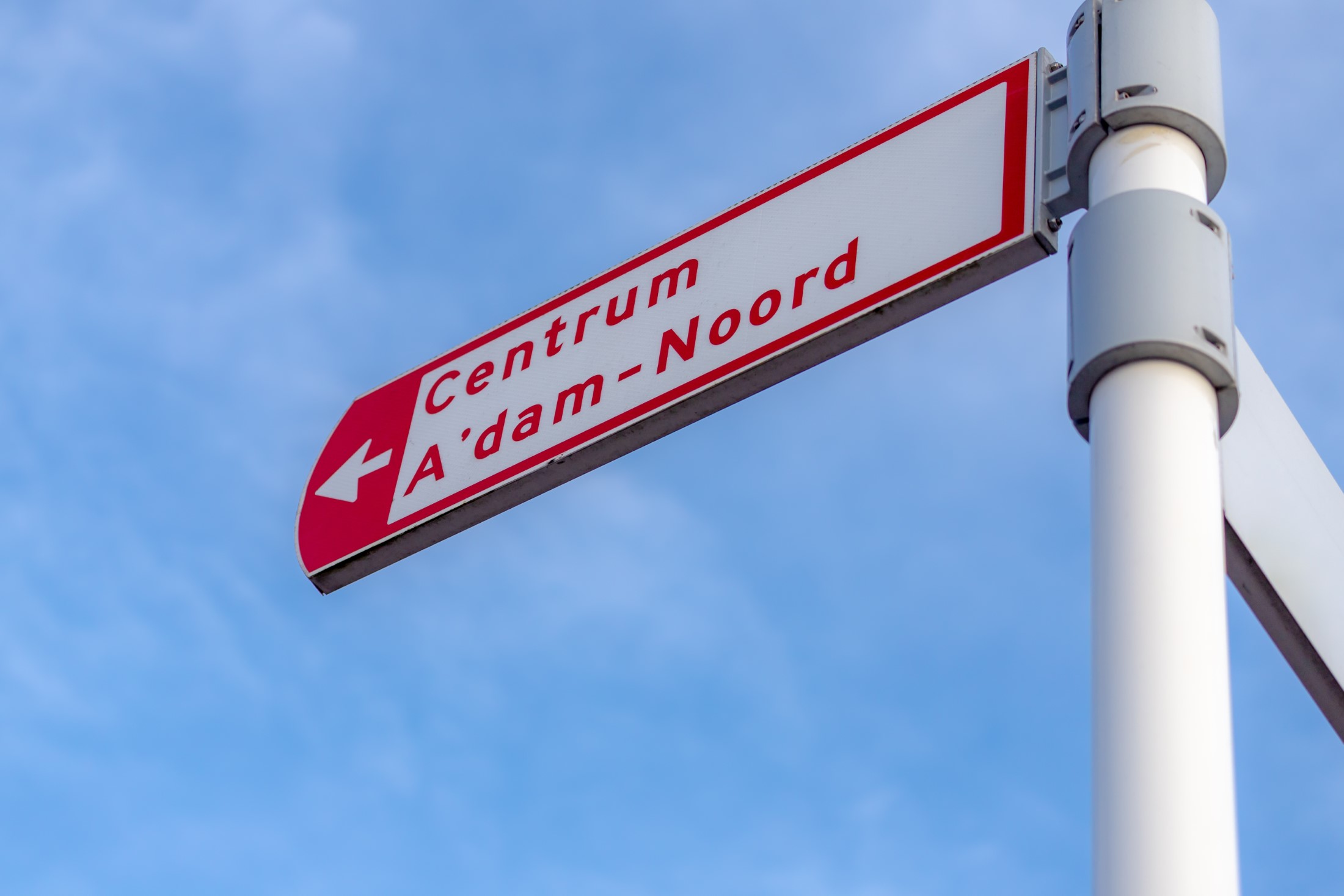 Selektywne skupienie tablicy znaków przewodnika w centrum miasta pod błękitnym niebem jako tło, poczta kierunkowa do Centrum (centrum) A'dam-Noord (Amsterdam North) Holandia