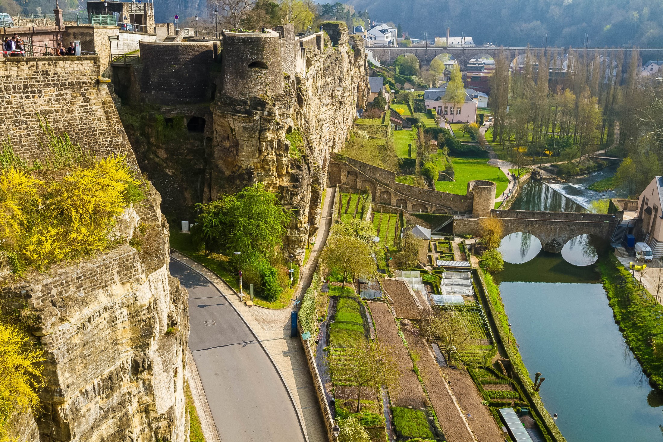 Panoramiczny widok na stare miasto w Luksemburgu wczesną wiosną. Starożytny kamienny most nad rzeką Alzette. Casemates du Bock, tarasy z ogrodami.